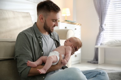 Photo of Father with his newborn son at home