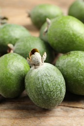 Photo of Fresh green feijoa fruits on wooden table, closeup