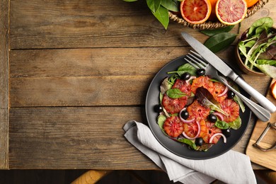 Delicious sicilian orange salad served on wooden table, flat lay. Space for text