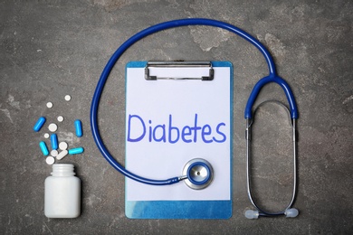 Photo of Flat lay composition with word "Diabetes", stethoscope and medicine on grey background