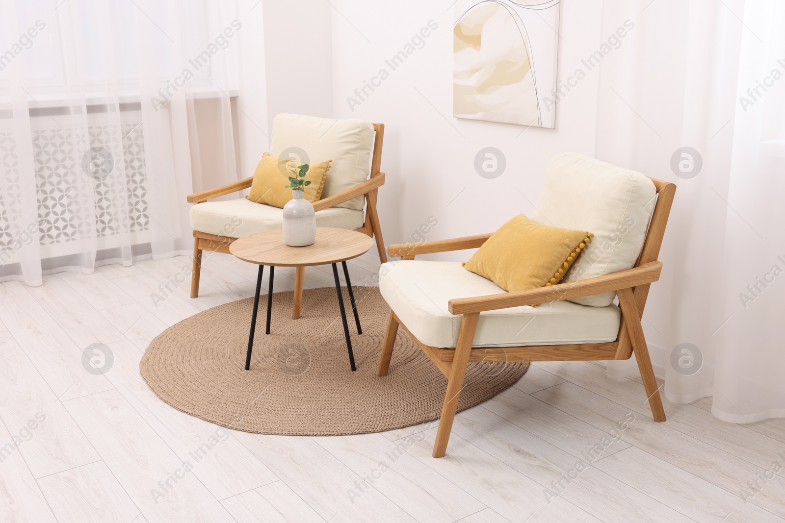 Photo of Stylish armchairs and wooden table in living room. Interior design