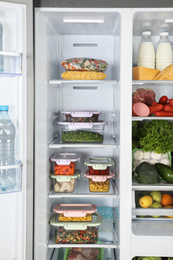 Open refrigerator full of different fresh products