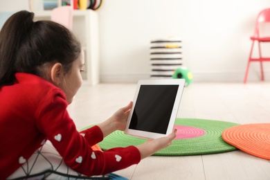 Little girl using video chat on tablet in playroom. Space for text