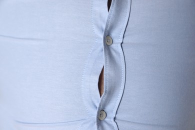 Photo of Overweight man in tight shirt as background, closeup