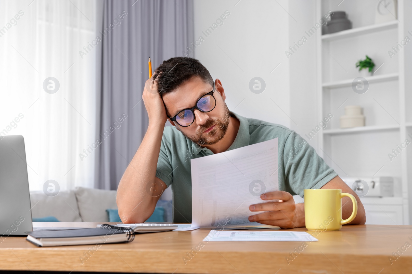 Photo of Man doing taxes at table in room