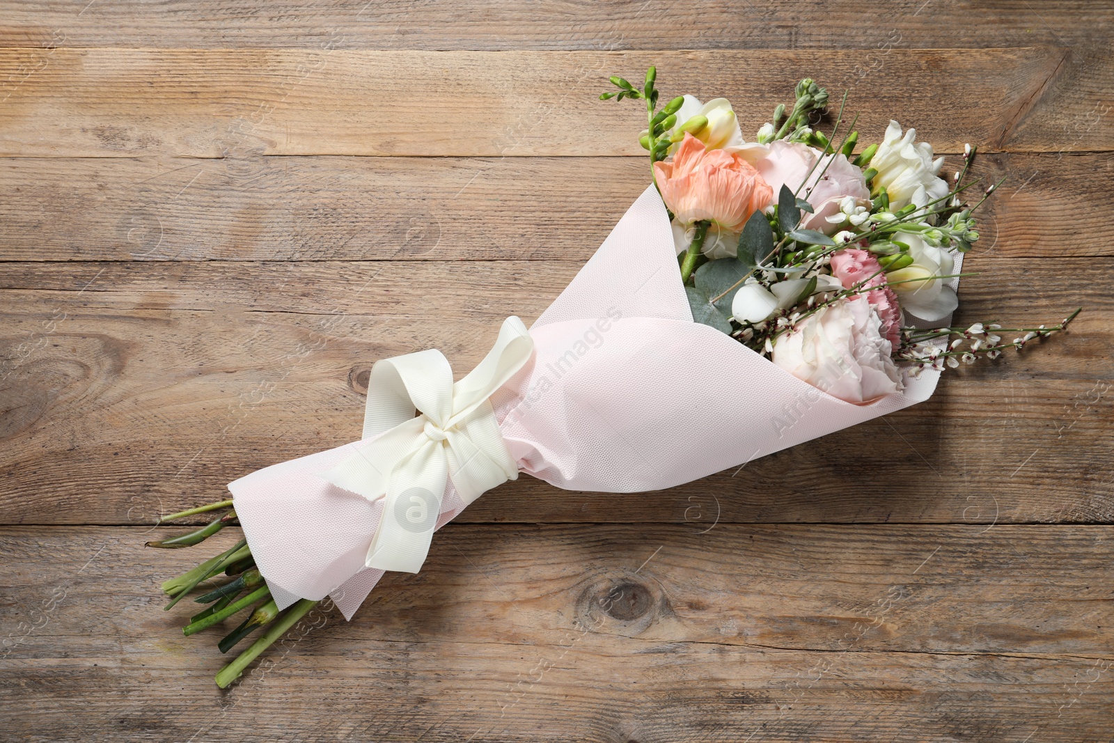 Photo of Bouquet of beautiful flowers on wooden table, top view