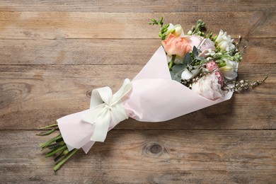 Bouquet of beautiful flowers on wooden table, top view