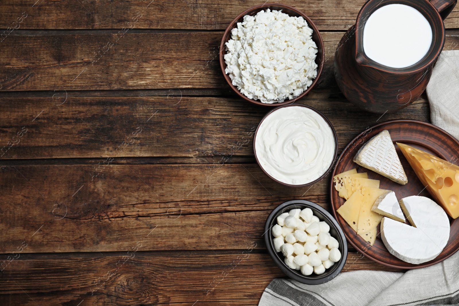 Photo of Flat lay composition with dairy products and clay dishware on wooden table. Space for text