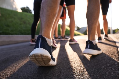 Photo of Group of people running outdoors on sunny day, closeup view