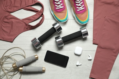 Photo of Stylish sportswear and equipment on light wooden background, flat lay