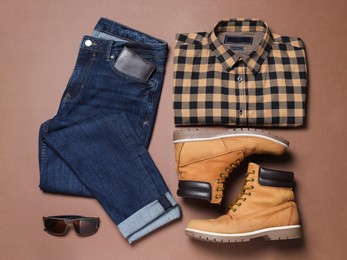 Photo of Flat lay composition with stylish men's clothes and boots on brown background