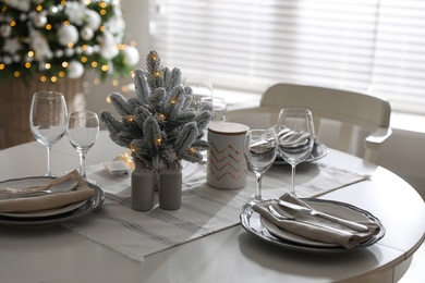 Photo of Festive table setting and beautiful Christmas decor indoors. Interior design