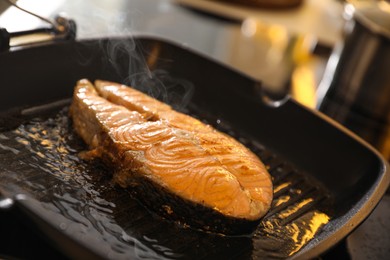 Photo of Frying pan with cooked salmon steak, closeup