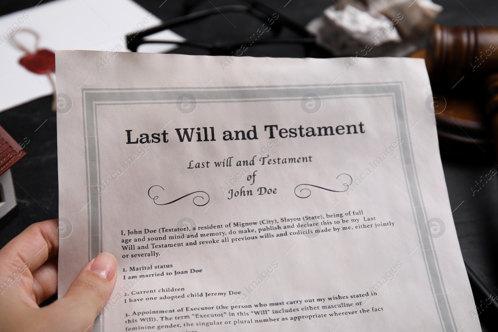 Photo of Woman holding last will and testament at black table, closeup