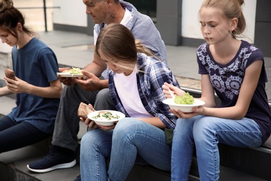 Poor people eating donated food on street