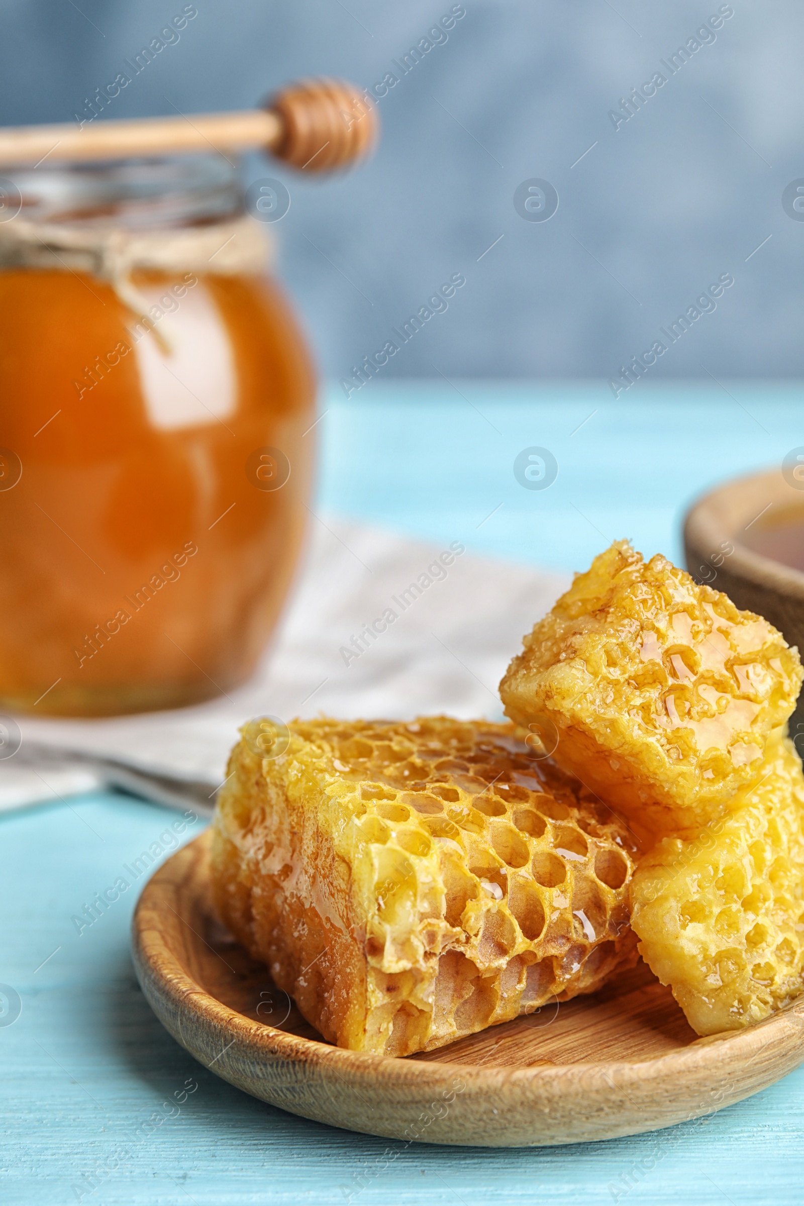 Photo of Fresh delicious honeycombs on light blue wooden table, closeup