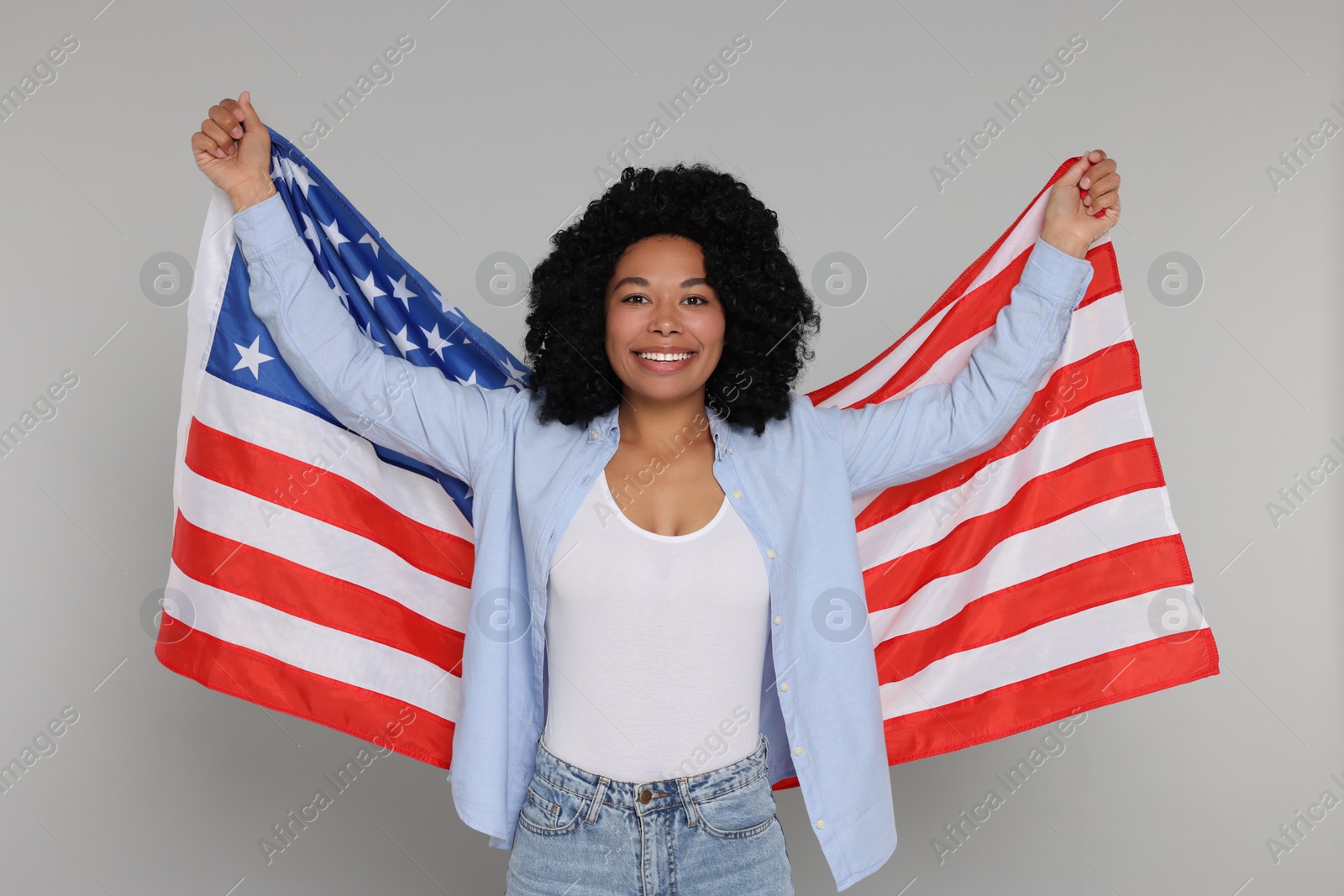 Photo of 4th of July - Independence Day of USA. Happy woman with American flag on light grey background