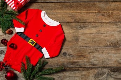 Photo of Flat lay composition with Christmas baby clothes on wooden background. Space for text