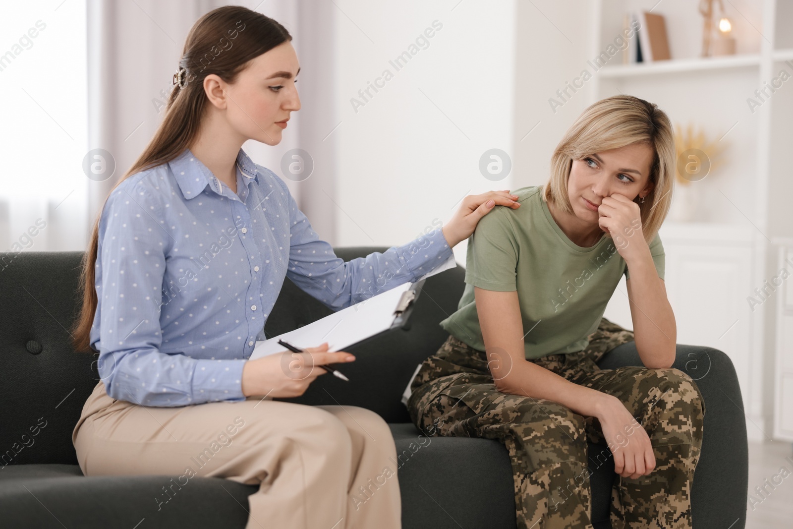 Photo of Psychotherapist working with military woman on sofa in office