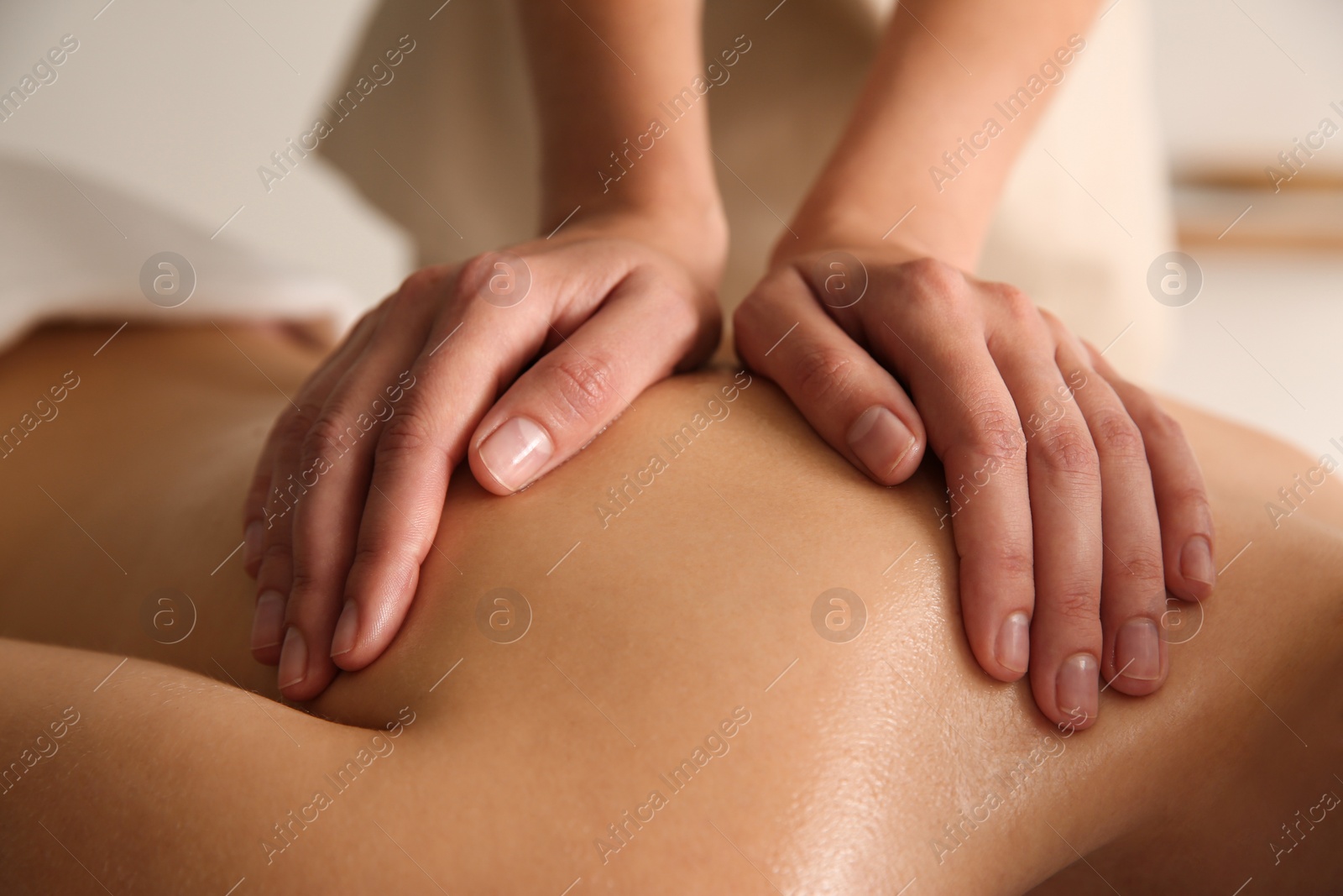 Photo of Young woman receiving back massage in spa salon, closeup