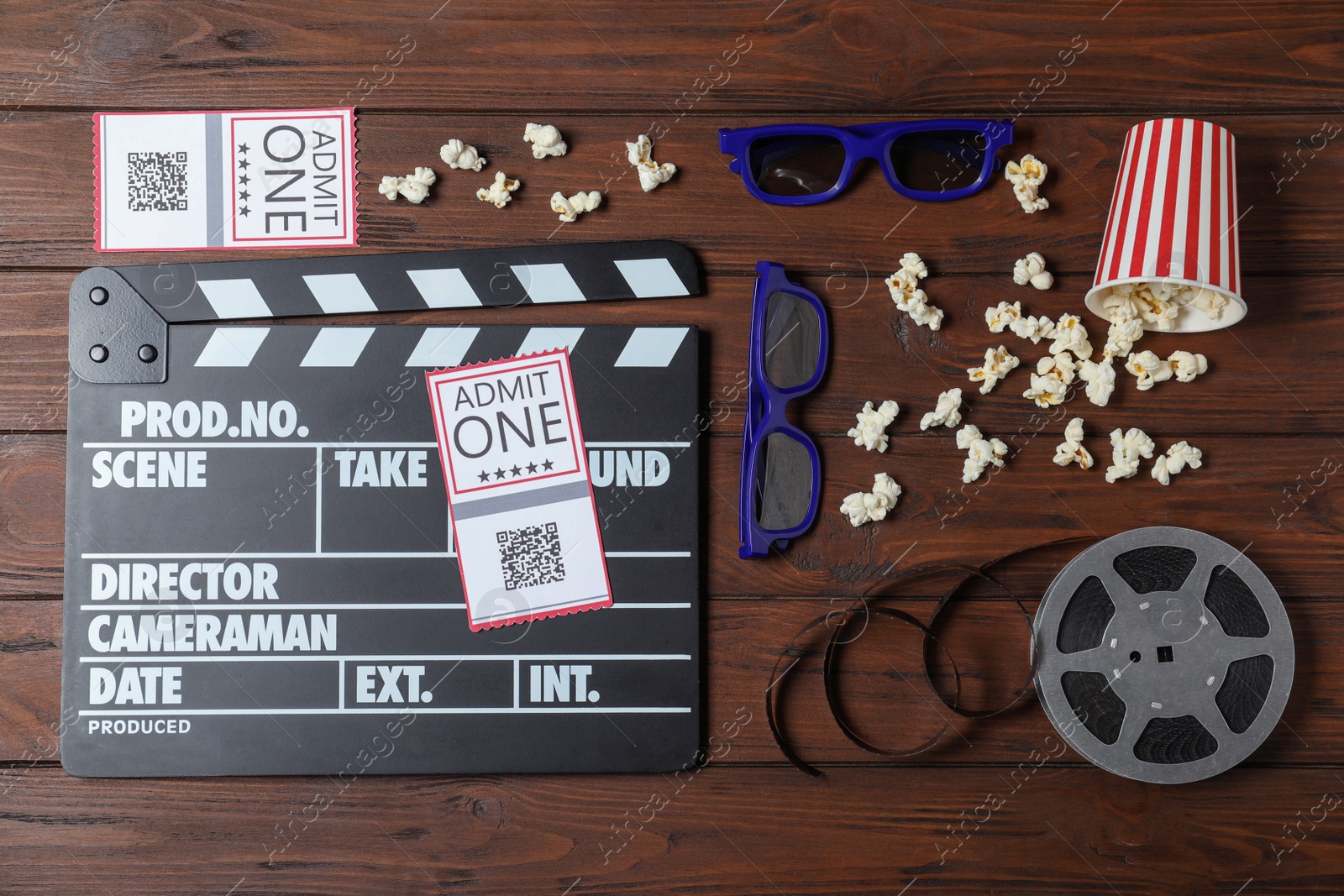 Photo of Flat lay composition with clapperboard, cinema tickets and 3d glasses on wooden table