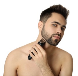 Photo of Handsome young man shaving with electric trimmer on white background