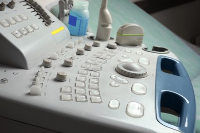 Photo of Ultrasound control panel with ultrasonic transducers and transmission gel in hospital, closeup. Medical equipment