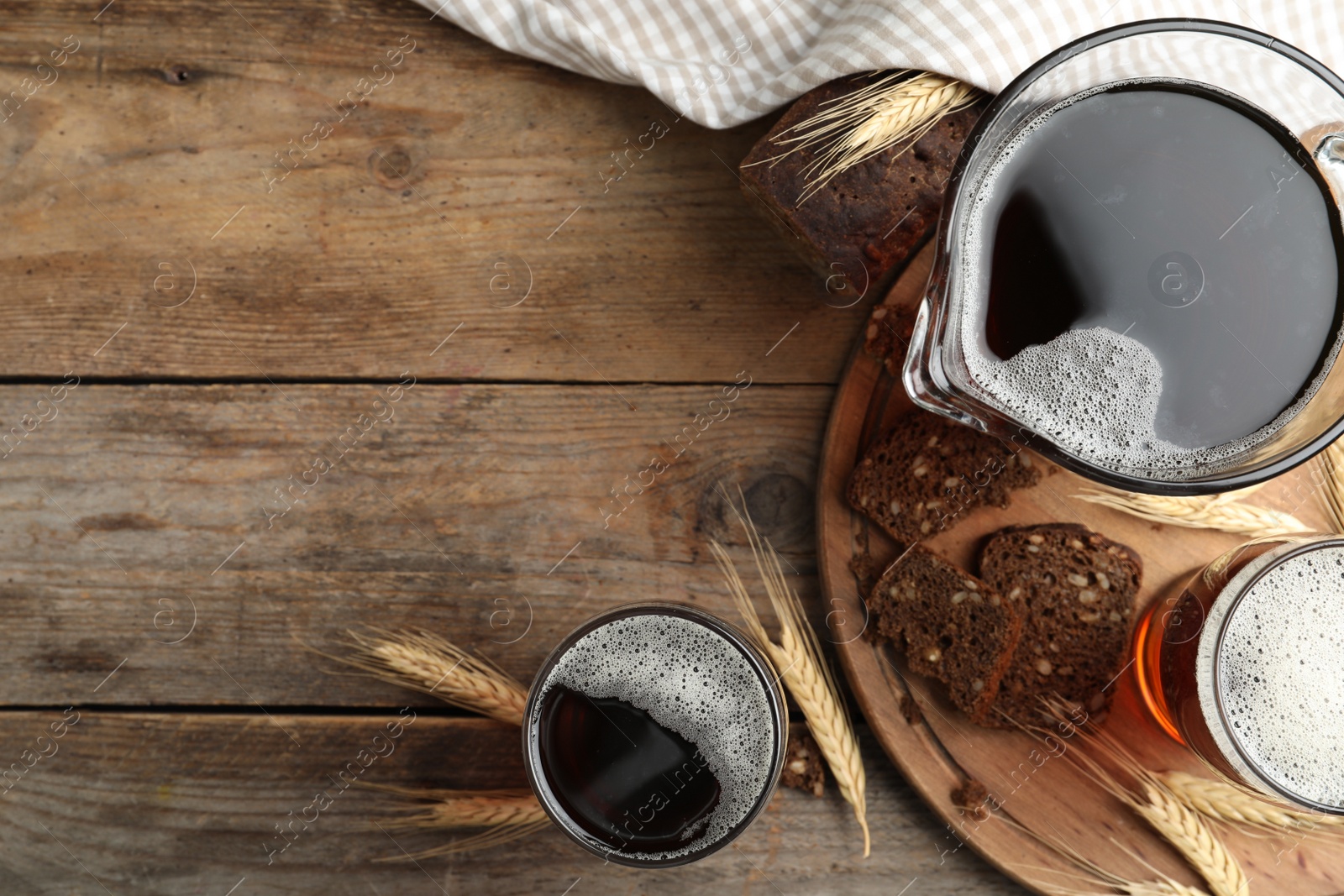 Photo of Delicious kvass, bread and spikes on wooden table, flat lay. Space for text