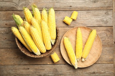 Tasty sweet corn cobs on wooden table, flat lay