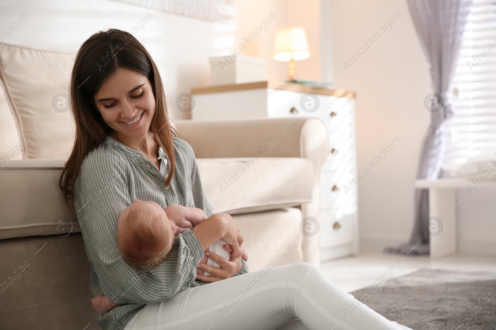 Photo of Mother with her newborn baby at home. Space for text