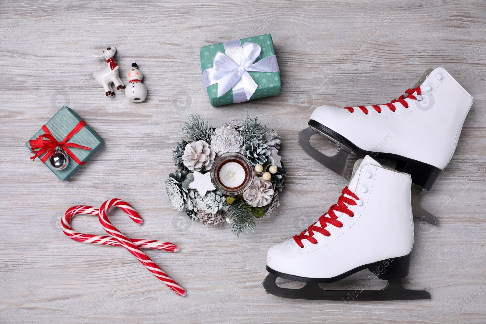 Photo of Pair of ice skates, Christmas decor and gift boxes on white wooden background, flat lay