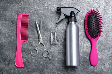 Photo of Flat lay composition of professional scissors and other hairdresser's equipment on grey table. Haircut tool