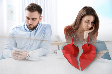 Double exposure with couple addicted to smartphones ignoring each other and halves of torn paper heart pinned on laundry string. Relationship problems