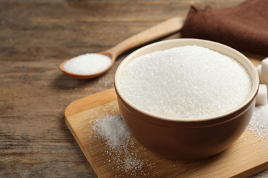 Granulated sugar in bowl on wooden table