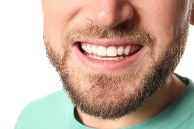 Young man with healthy teeth on white background, closeup