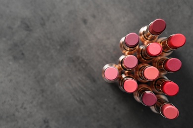Photo of Set of bright lipsticks on grey background, flat lay. Space for text