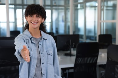 Photo of Happy woman welcoming and offering handshake in office, space for text