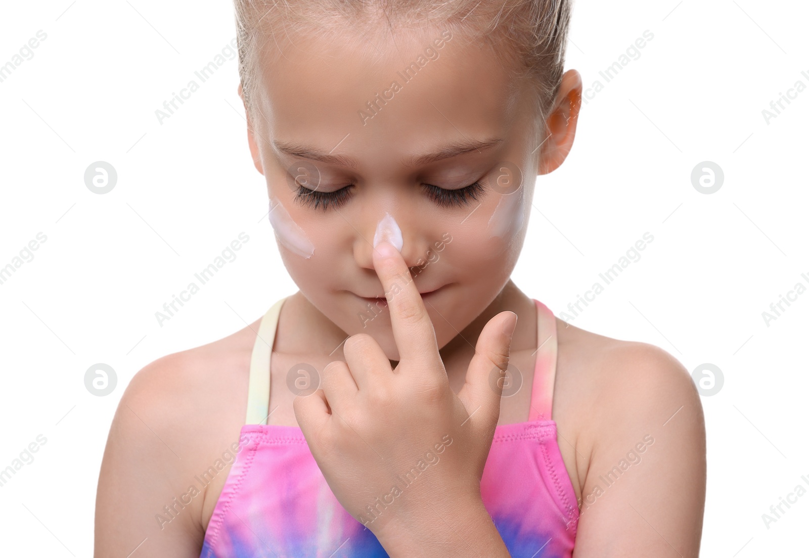 Photo of Cute girl applying sun protection cream onto her face against white background