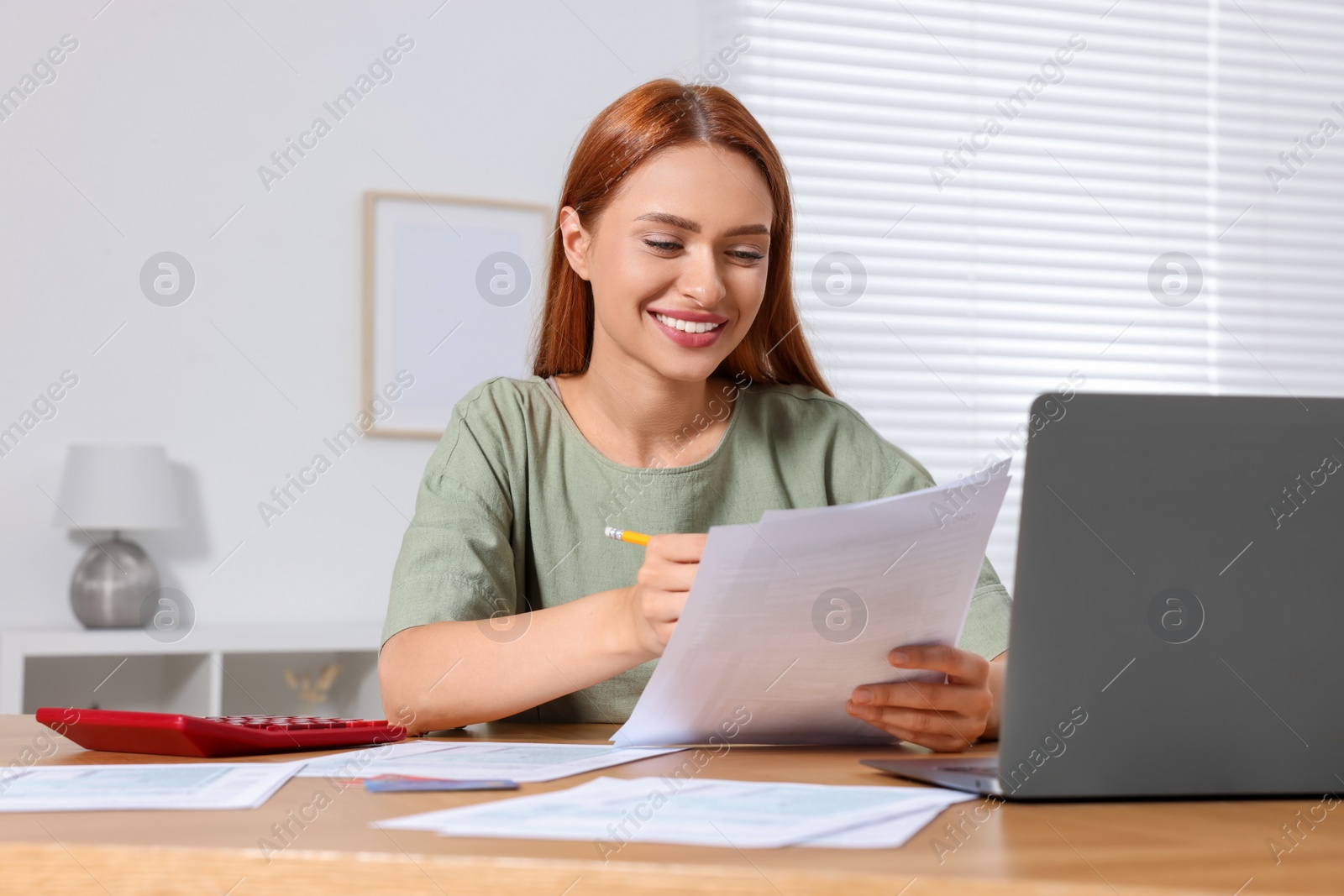 Photo of Woman doing taxes at table in room