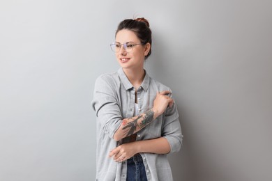 Photo of Portrait of beautiful tattooed woman on gray background