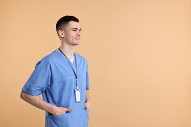 Photo of Portrait of smiling medical assistant on beige background. Space for text