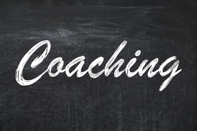 Image of Adult learning. Word Coaching written on black chalkboard