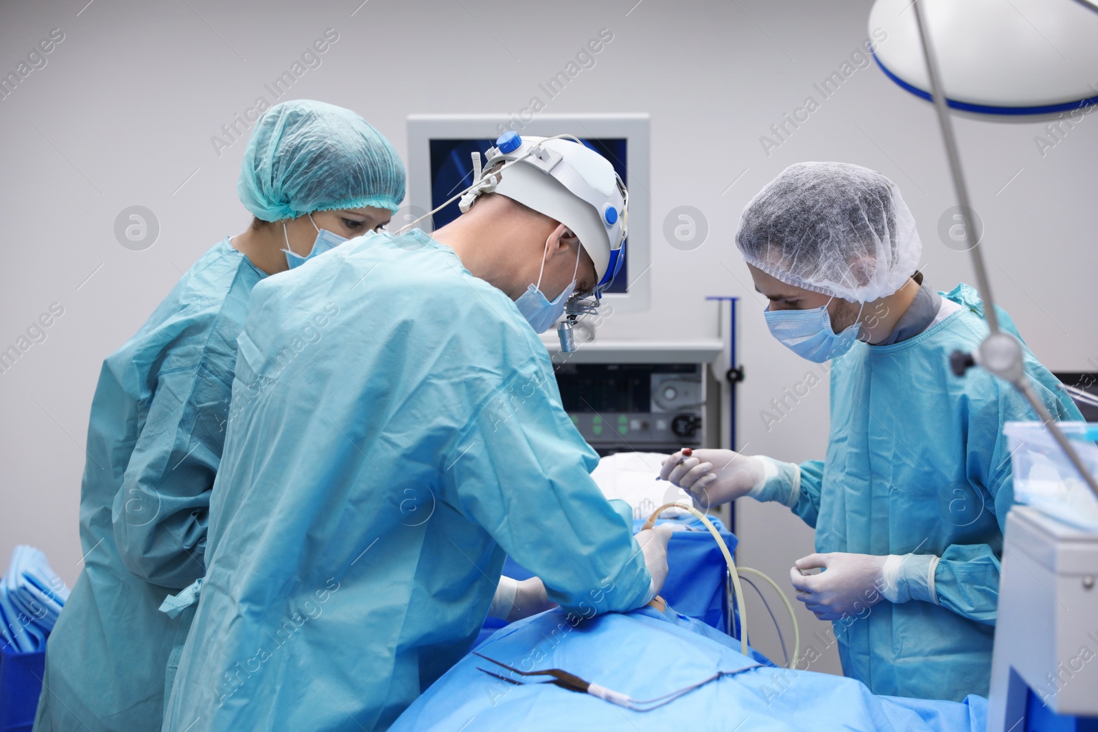 Photo of Team of professional doctors performing operation in surgery room