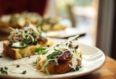 Delicious bruschettas with fish on table, closeup