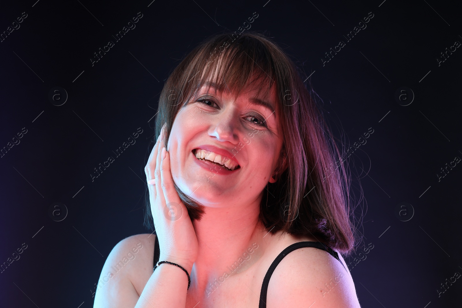 Photo of Portrait of happy woman on dark background