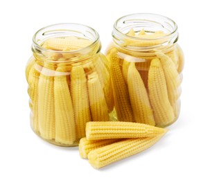 Photo of Jars and pickled baby corn isolated on white