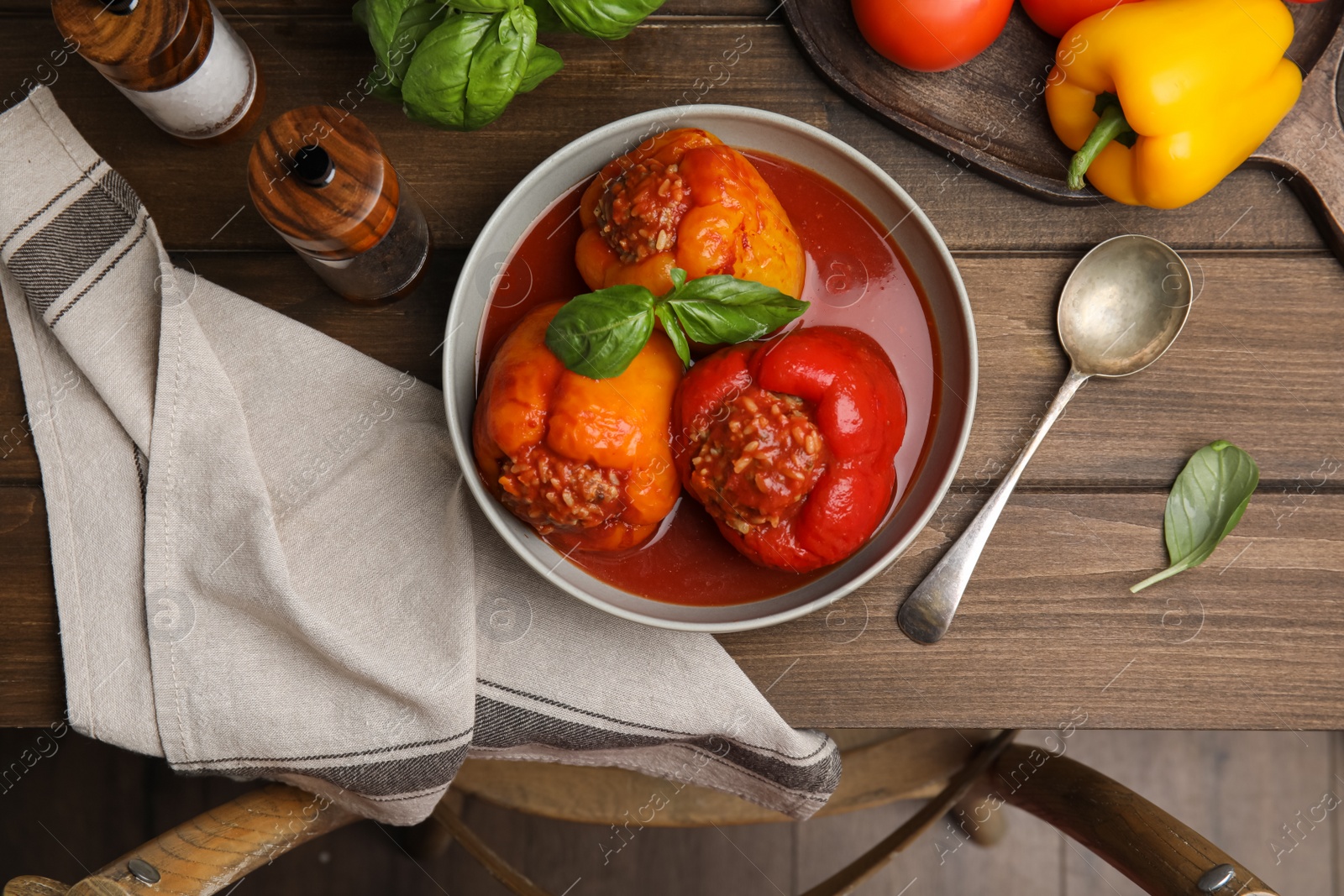 Photo of Delicious stuffed peppers served on wooden table, flat lay