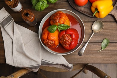 Delicious stuffed peppers served on wooden table, flat lay