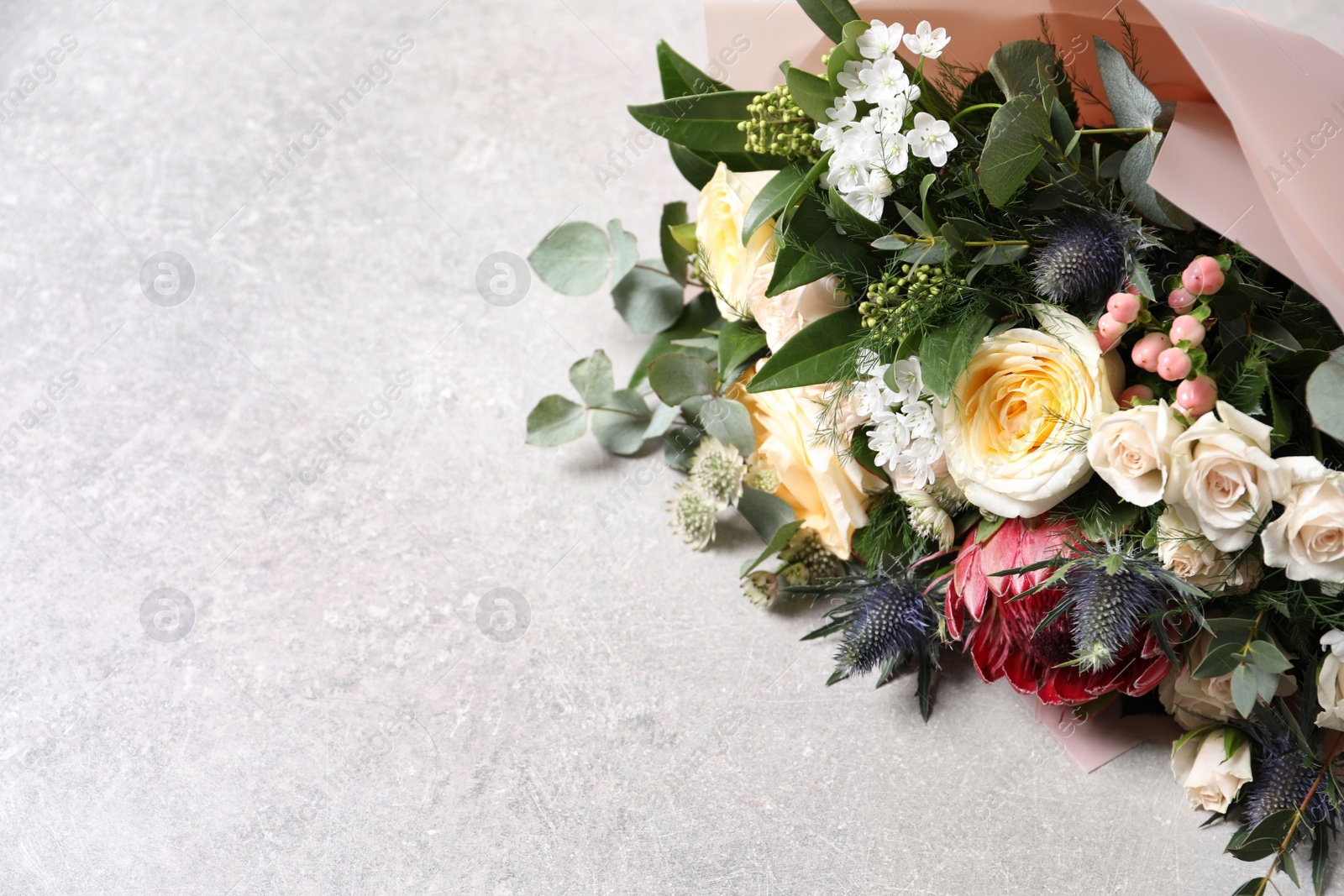 Photo of Beautiful bouquet with roses on light background. Space for text