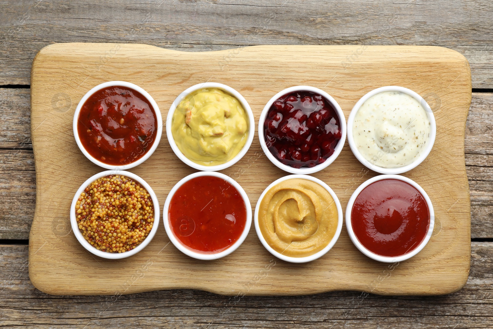 Photo of Different tasty sauces in bowls on wooden table, top view